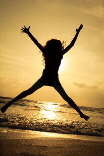 夕阳下海边跳跃的活力身影