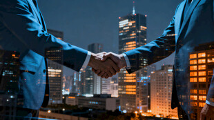 商务人士夜幕下握手合作