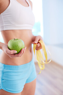 女子手持青苹果与卷尺