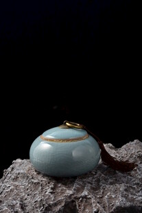 浅蓝色陶瓷摆件置于石上