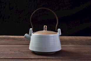 白色提梁茶壶置于木桌