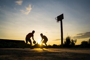 夕阳下的玩篮球场景