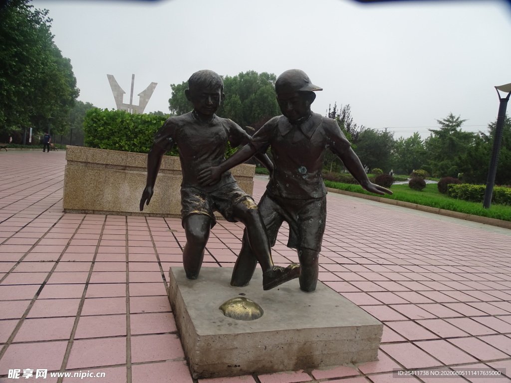 两个小孩玩足球雕塑