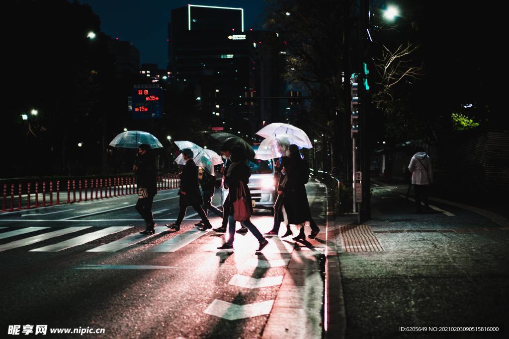 雨夜撑伞过人行道的行人