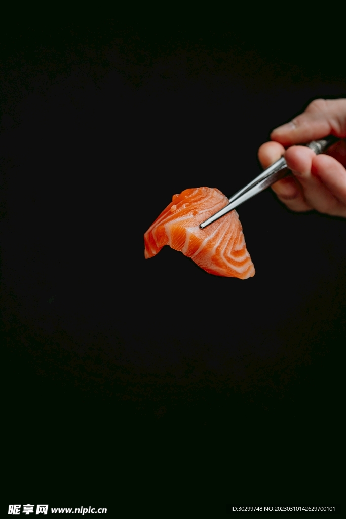 高清黑色背景人手筷子夹三文鱼