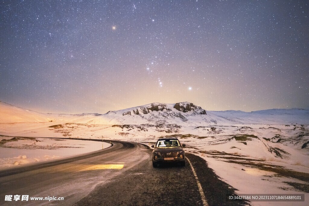 星空下雪山路上的汽车