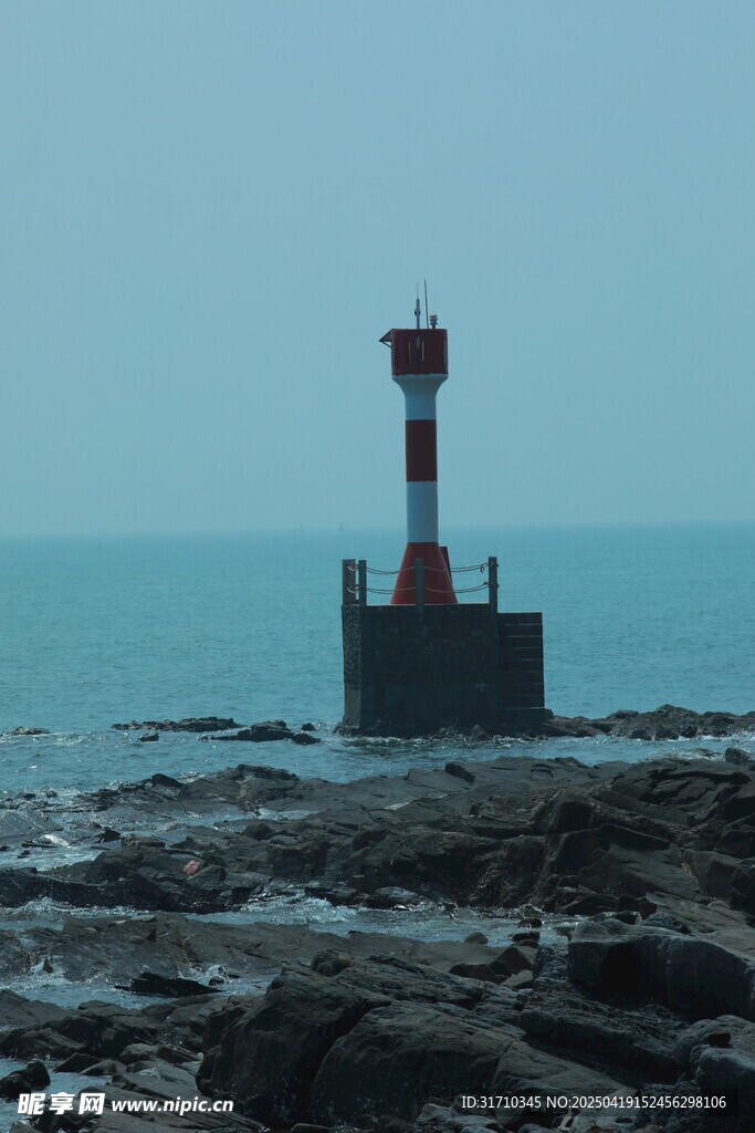 海边礁石上的红白灯塔