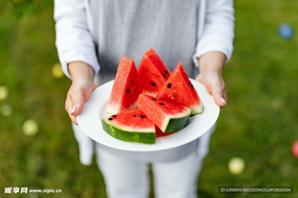 手捧西瓜盘于绿意中
