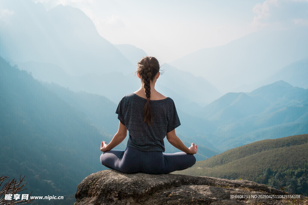 女子山顶静坐冥想赏美景