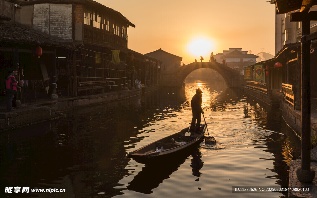 夕阳下的水乡撑船景象