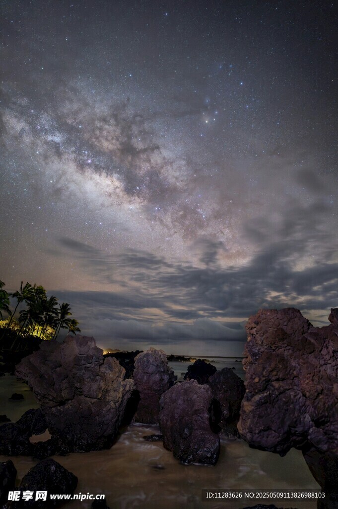 海边夜空下的岩石与星云