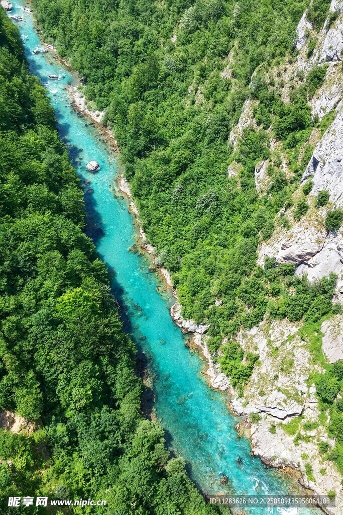 航拍翠绿山林间的蓝绿色河流