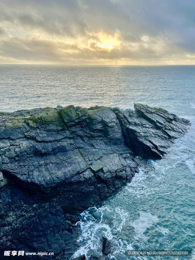 海边礁石处的壮丽日落景观