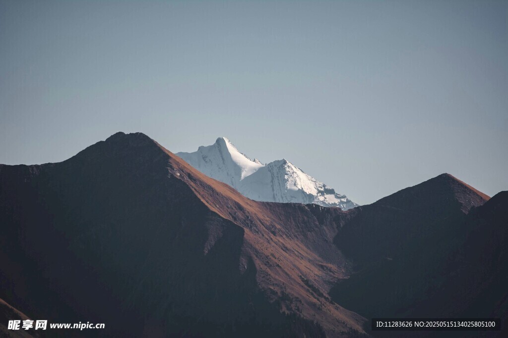 雪山映于山峦间壮丽景色