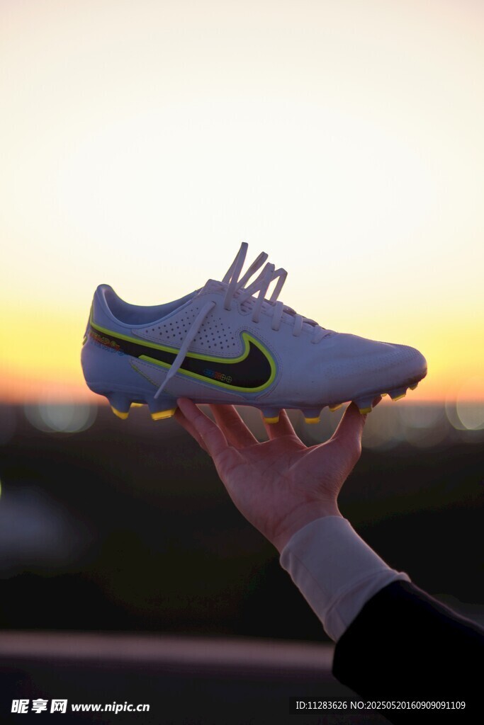 夕阳下手持时尚运动鞋