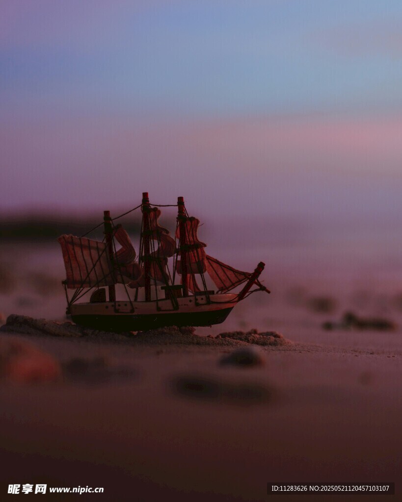 夕阳下的沙滩古帆船