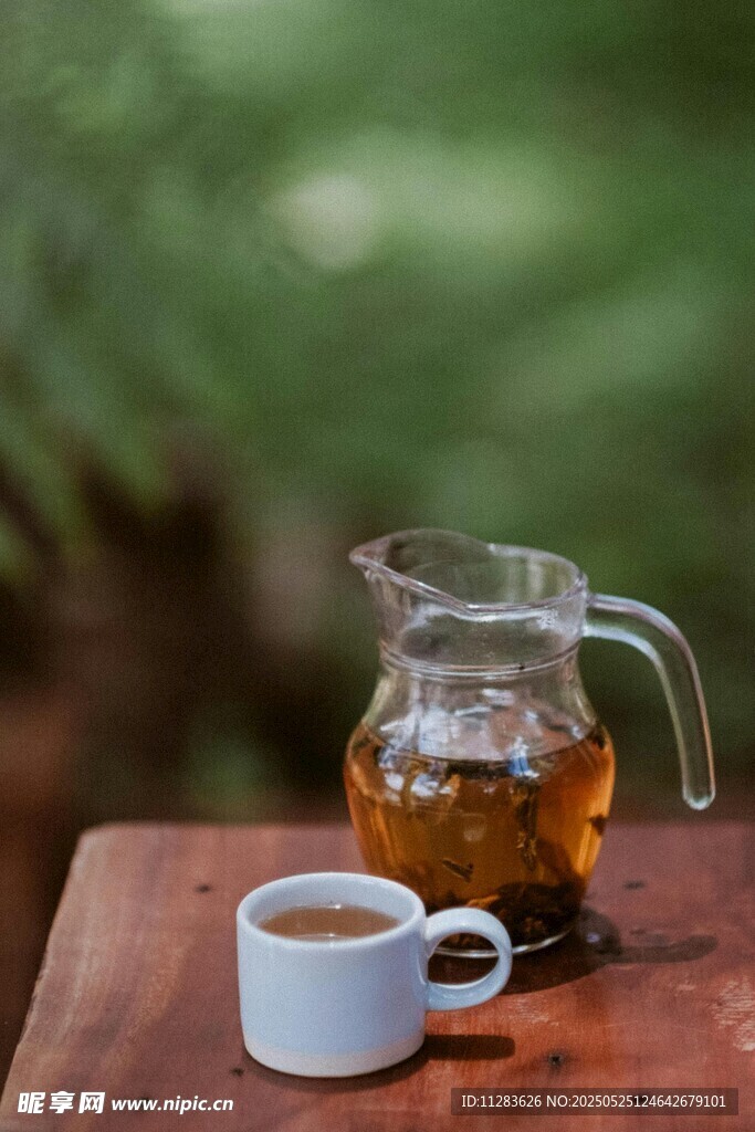 木桌上的玻璃茶壶与茶杯