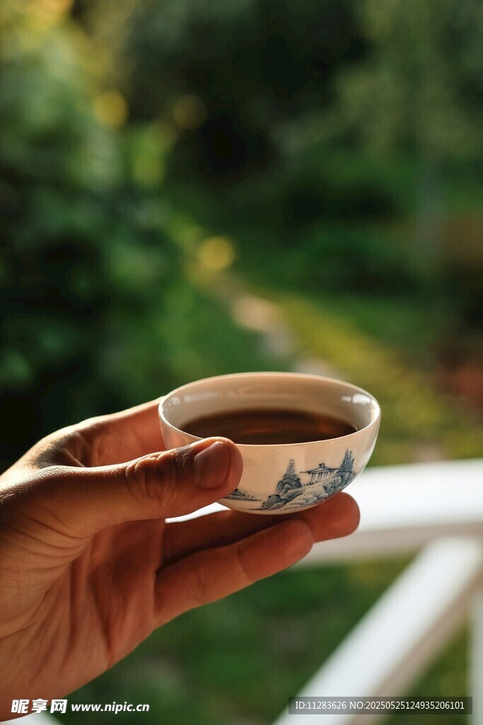 手持精致茶杯赏景
