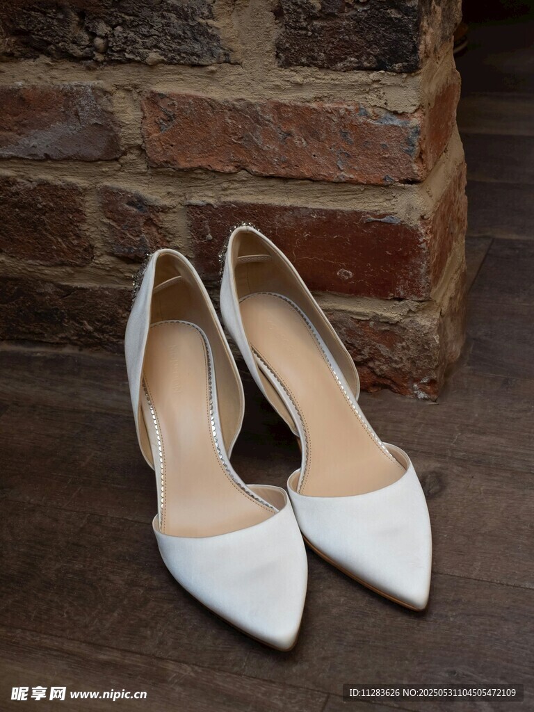 白色尖头高跟鞋靠墙摆放