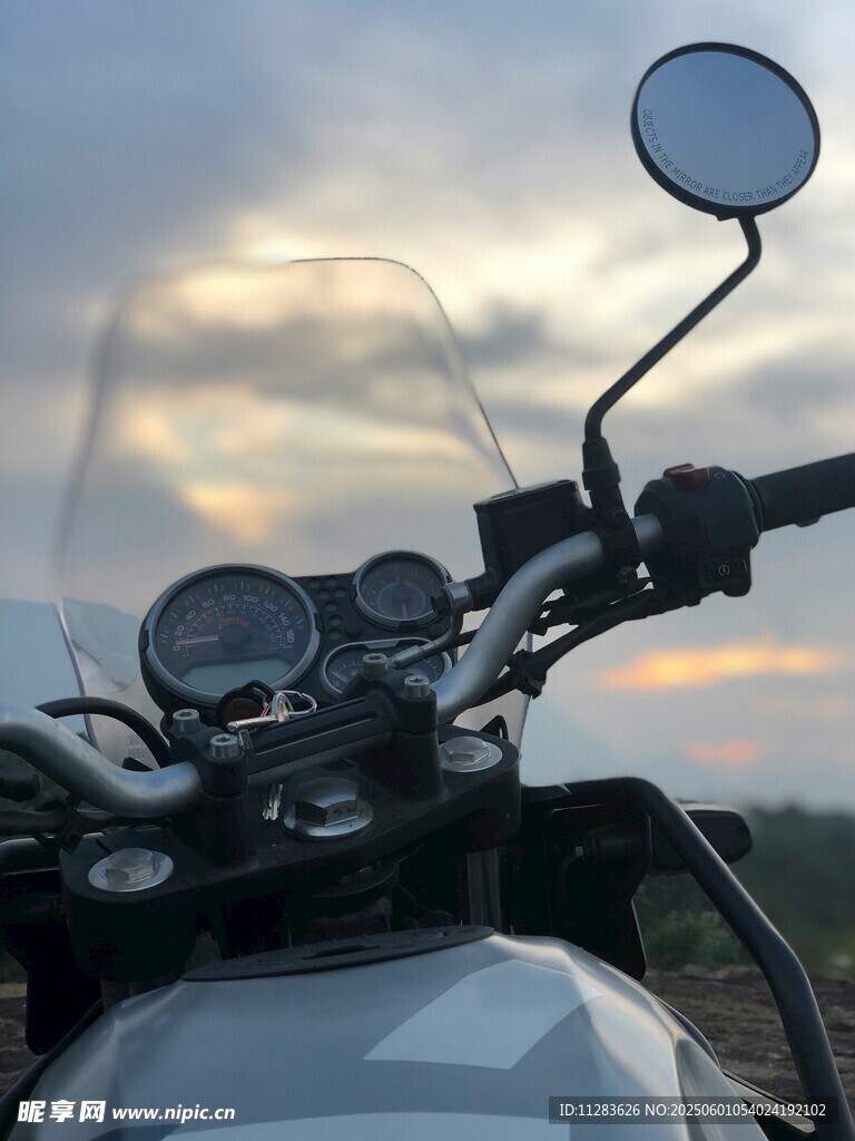夕阳下的摩托车车头特写