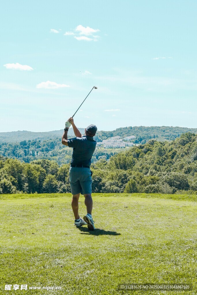 男子于草地挥杆打高尔夫
