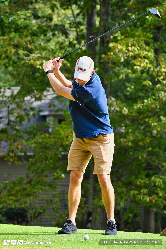 男子专注挥杆打高尔夫