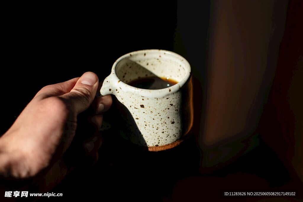 手持古朴陶瓷咖啡杯