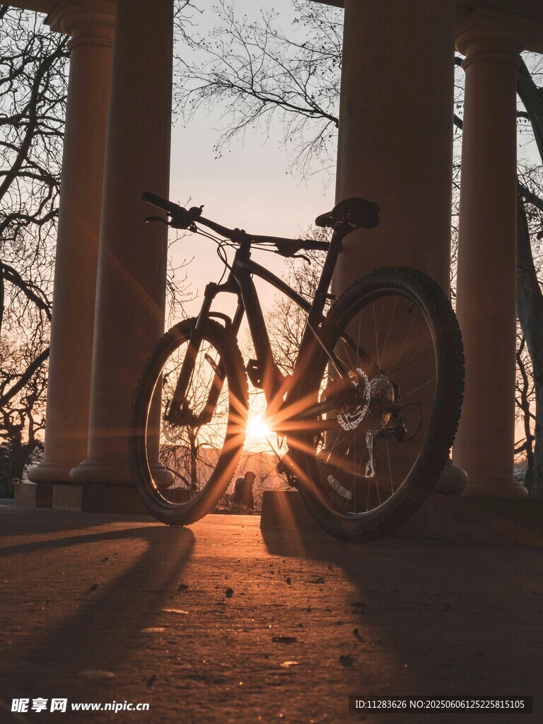 夕阳下靠柱而立的自行车