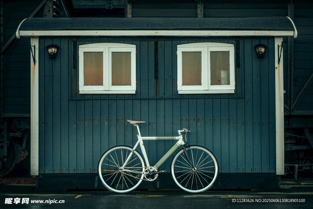 蓝墙小屋旁的简约白色单车