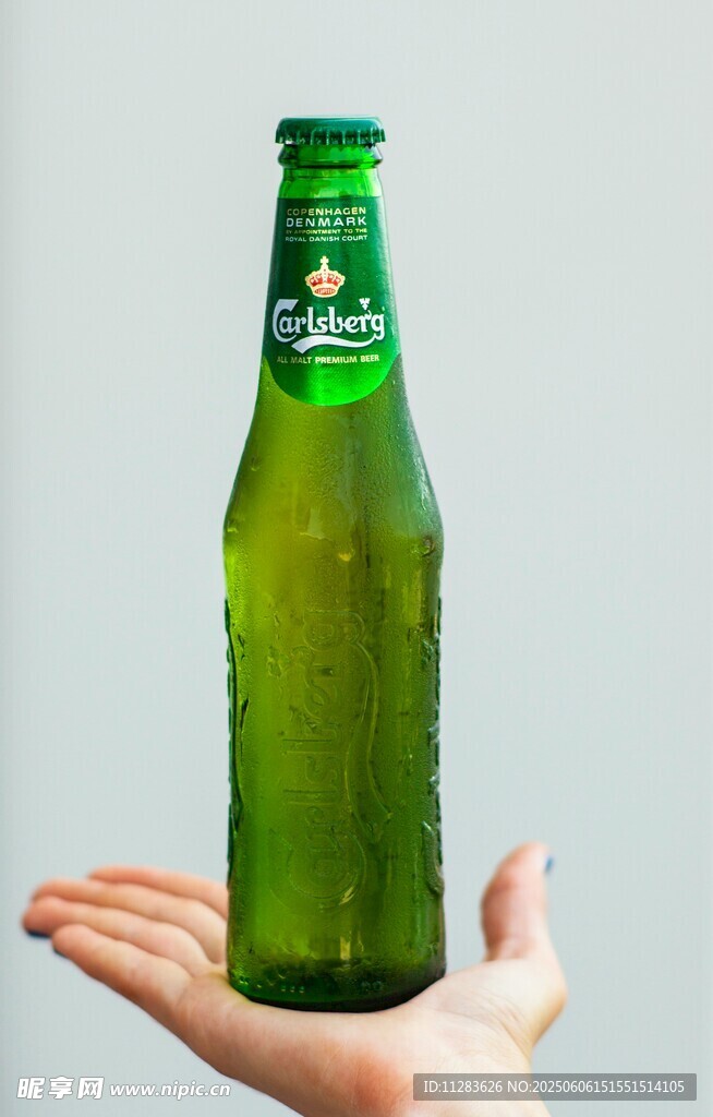 手托绿色啤酒瓶特写