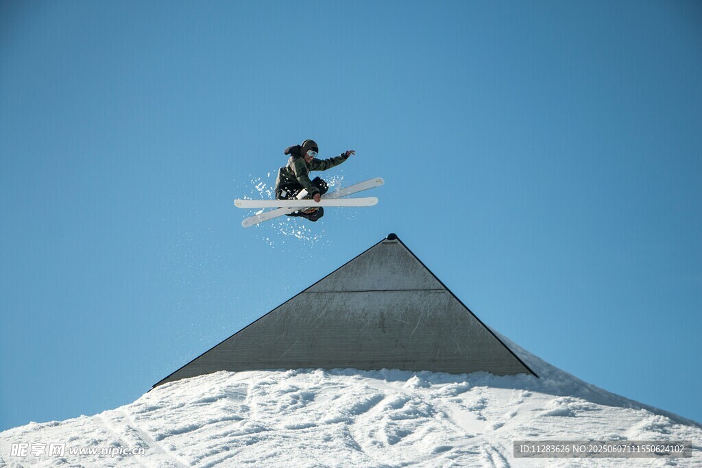 滑雪者空中飞跃雪山尖