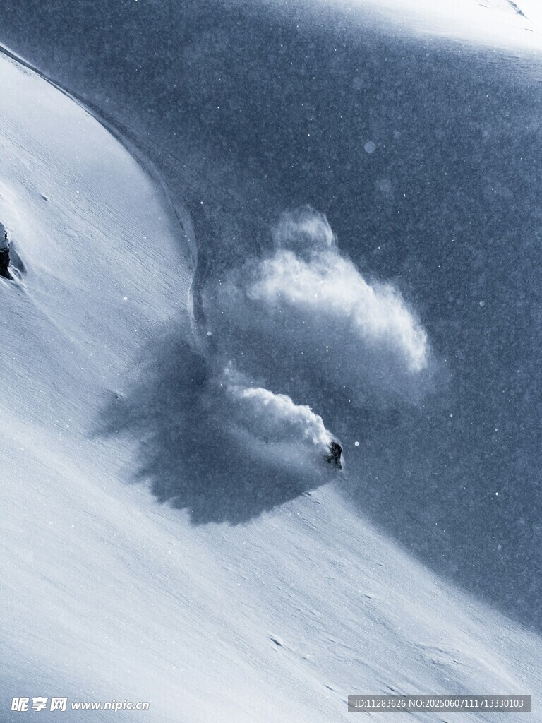 滑雪者在雪坡激起雪雾