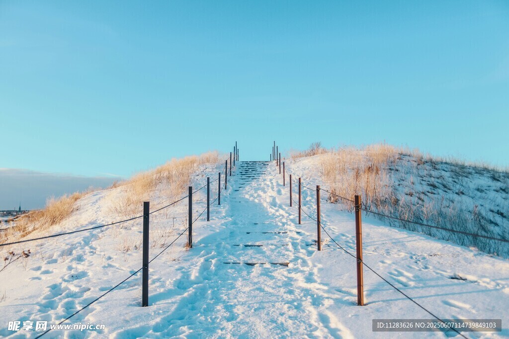 雪覆山坡的围栏小径