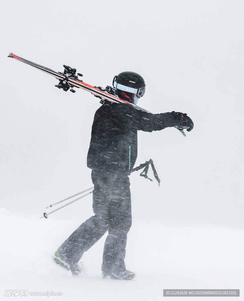 雪中扛滑雪装备的运动员