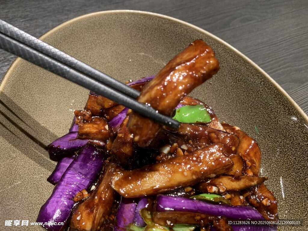 筷子夹起美味茄子炒肉
