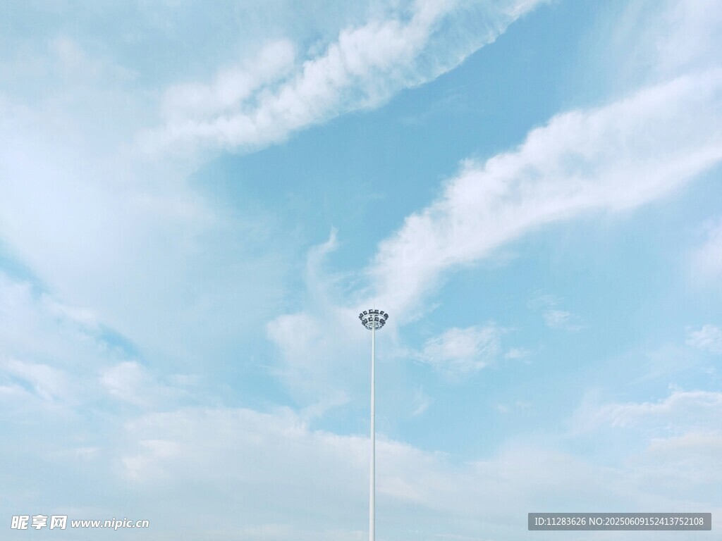 蓝天白云下的高耸路灯