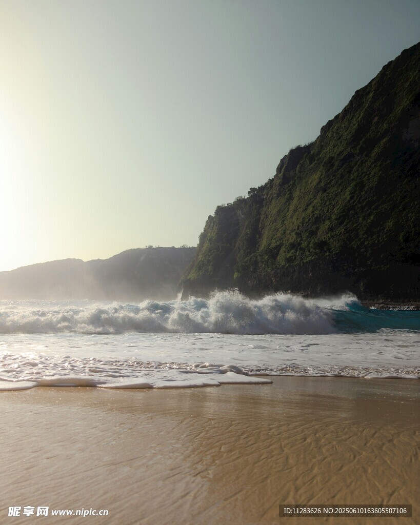 阳光沙滩海浪与陡峭山崖