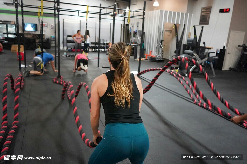 健身房中女子奋力战战绳