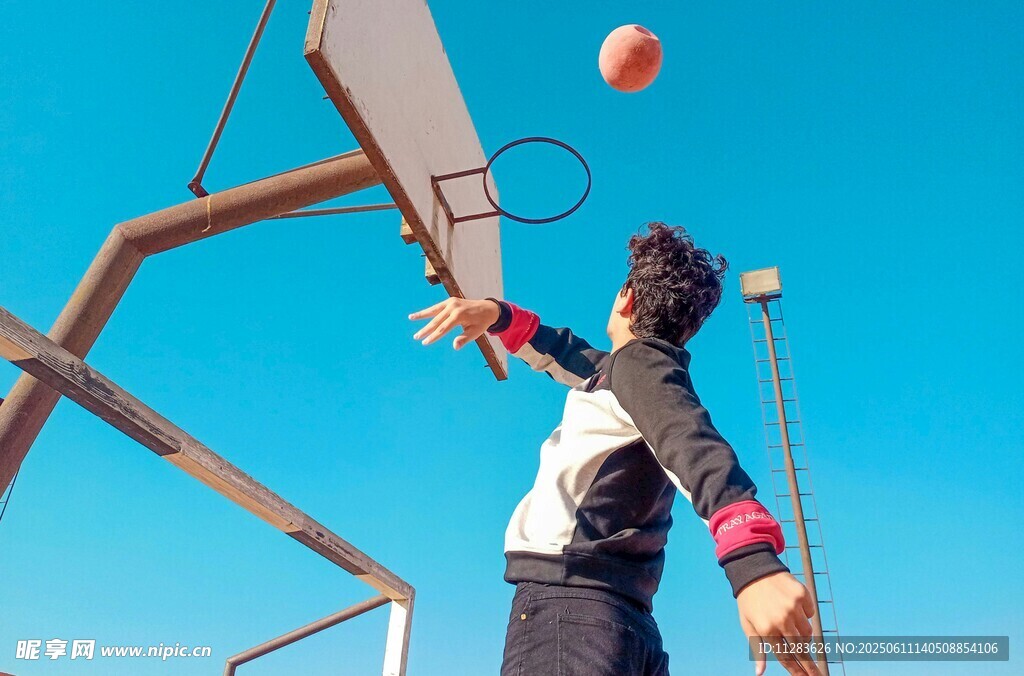 少年户外篮球场上奋力投篮