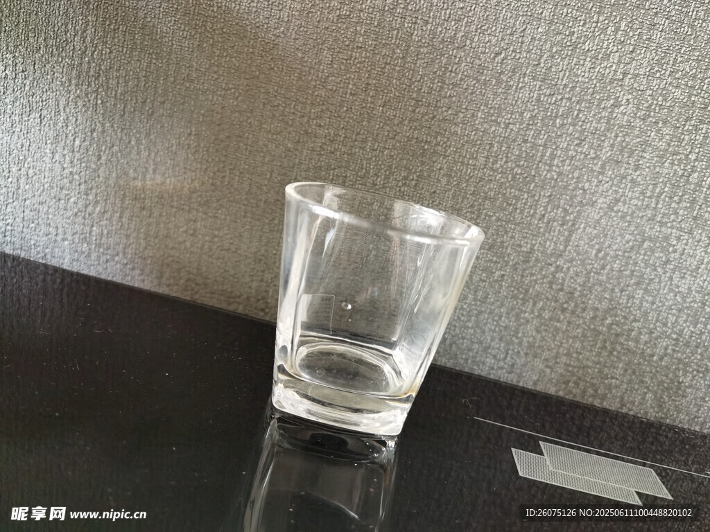 透明玻璃杯置于黑色桌面