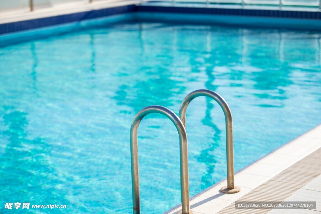 清澈泳池边的金属扶梯