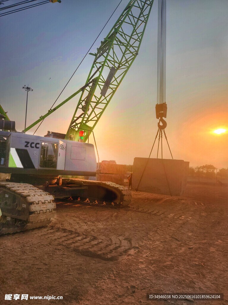 夕阳下的工地起重机作业