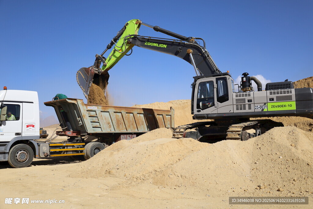 挖掘机向卡车装载沙土