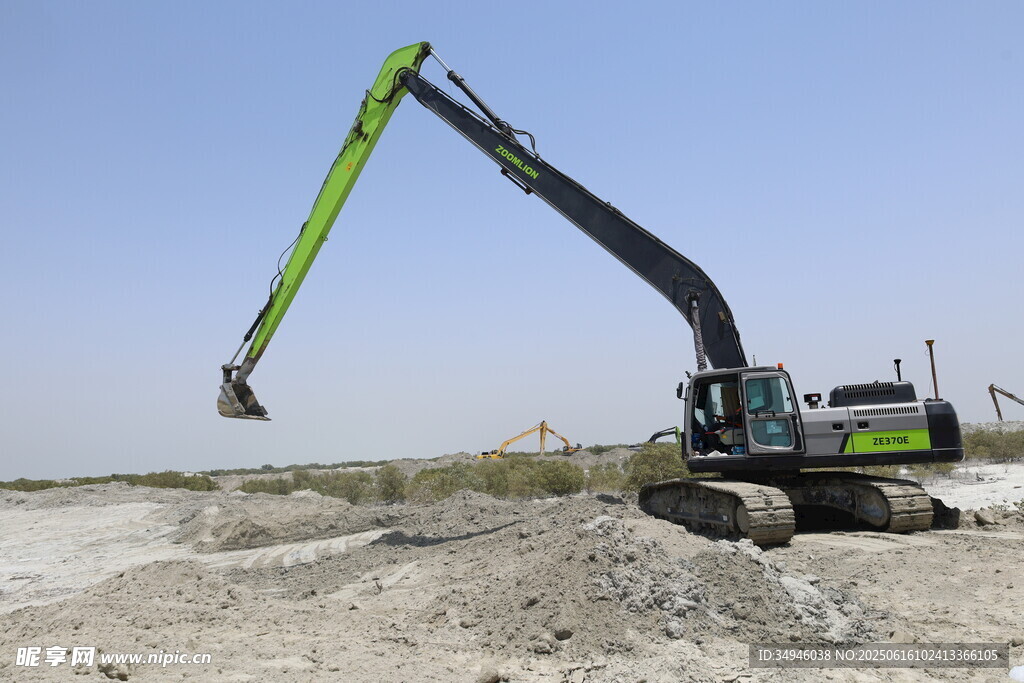 绿色挖掘机于沙地作业
