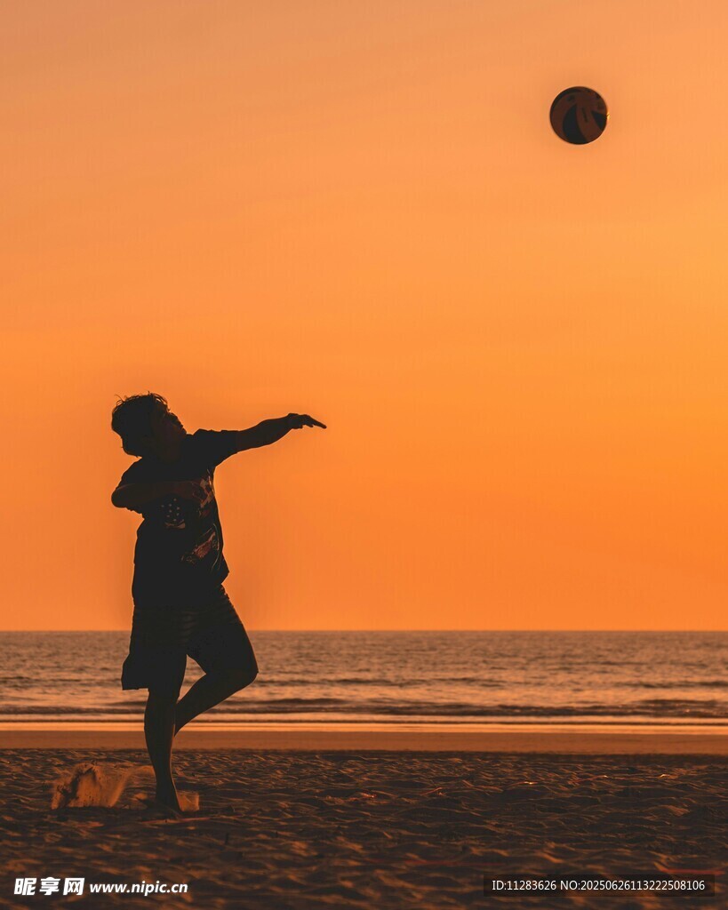 夕阳下海边踢足球的身影