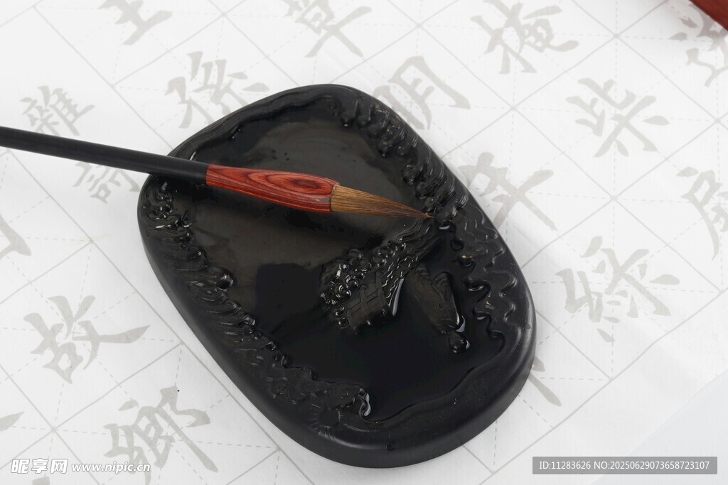 毛笔蘸墨于砚台