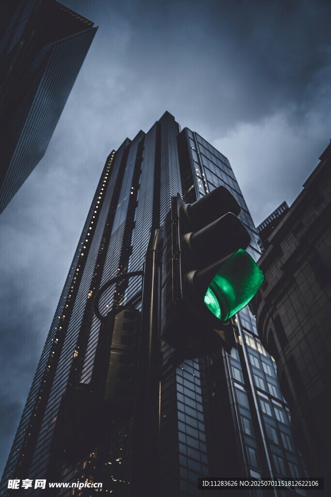 都市高楼间的绿色交通信号灯
