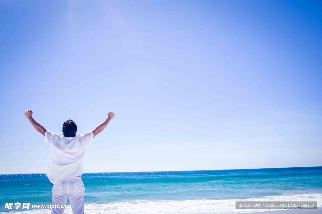 海边男子舒展双臂迎海风