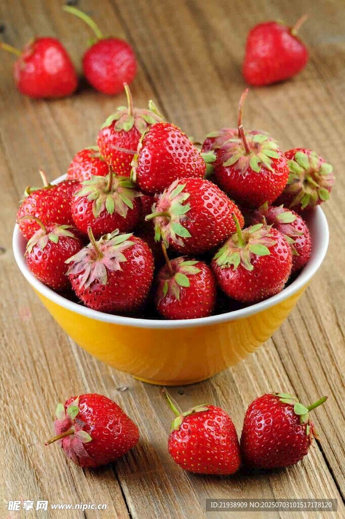 木桌上黄碗中的新鲜草莓