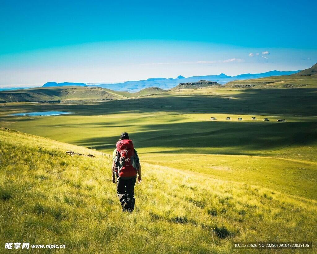 徒步者穿行于绿野山川间